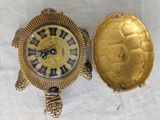a gold turtle clock sitting next to a gold turtle