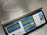 a digital scale sitting on top of a metal counter