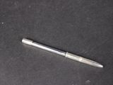 un stylo argenté posé sur une surface noire