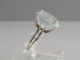 an image of a ring with a blue topaz stone on a clear stand