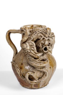 un vase marron sur lequel est représenté un visage