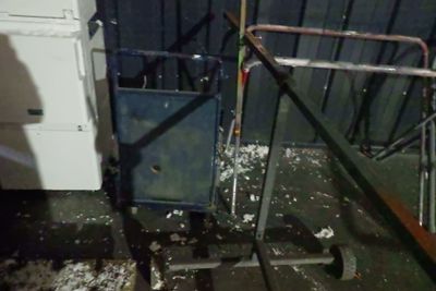 une pièce sale avec une machine à laver et un sèche-linge cassés posés par terre