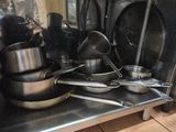 many pots and pans on the shelf in the kitchen
