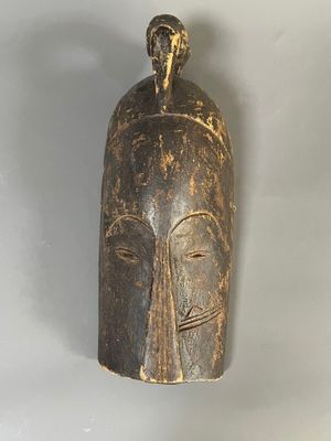 une image d'un masque en bois accroché au mur