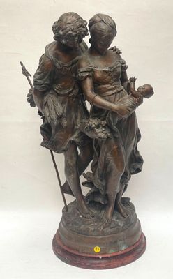 bronze statue of a couple holding a child on a wooden base