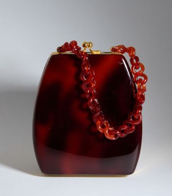 une photo d'un sac à main rouge entouré d'une chaîne
