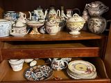 a wooden shelf with many different types of dishes on it