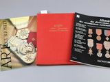 three books on a table with a red cover and a gold medal