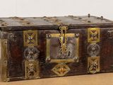 une boîte en bois ornée de décorations métalliques, posée sur une table