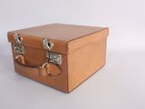 a small brown suitcase sitting on a white surface