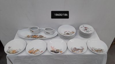 une table sur laquelle se trouvent beaucoup d'assiettes et de bols