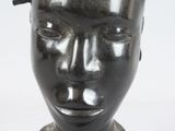 a sculpture of a head with a bird on top of it