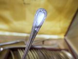 une cuillère en argent dans un coffret contenant des cuillères