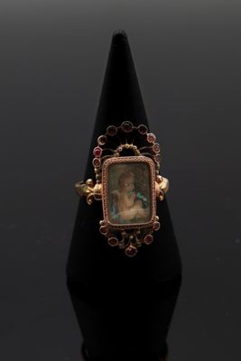 un gros plan d'une bague sur laquelle figure le portrait d'une femme