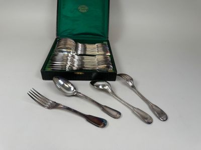 une boîte contenant des couverts, posée sur une table où se trouvent des fourchettes et des cuillères