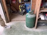 a man that is standing in a garage with a gas can