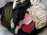 a pile of clothes that is sitting on a couch
