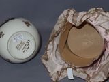 a white ball and a brown hat sitting next to each other