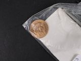 a penny sitting on top of a piece of paper next to a piece of paper
