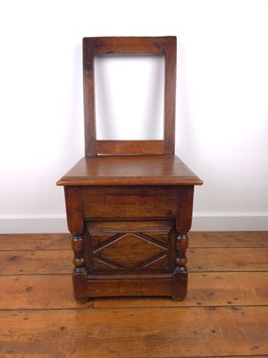 une vieille commode en bois surmontée d'un miroir, posée sur un parquet en bois massif