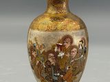 a gold vase with a picture of people on it