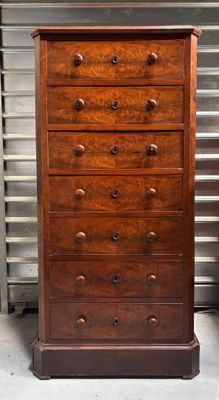 a tall wooden chest of drawers in a room
