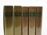 quatre livres sont alignés sur une surface blanche
