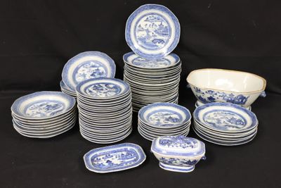 many blue and white plates and bowls on a black table
