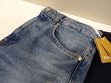 two pairs of jeans with tags on them sitting on a table