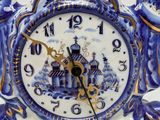 a blue and white clock sitting on top of a table