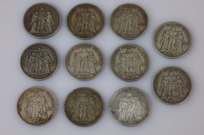 six types différents de pièces d'argent sur une surface blanche