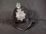 une casquette de policier ornée d'un insigne, sur fond noir