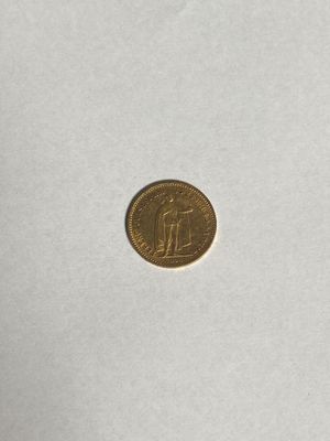 a close up of a gold coin on a white surface