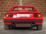 a red sports car parked in front of a brick wall