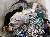a white bag full of clothes and a bottle of water