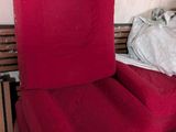 une chaise rouge qui se trouve dans le coin d'une pièce