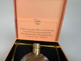 a bottle of perfume in a box on a table
