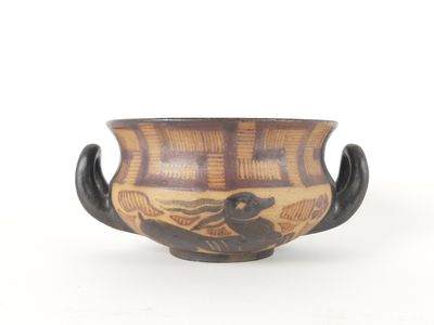 un bol marron et noir orné d'un oiseau