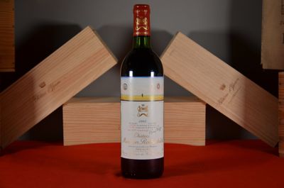 a bottle of wine sitting on a table next to wooden boxes