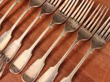 a lot of forks and spoons that are on a table