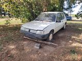 a white car that is parked in the dirt