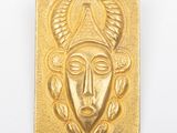 une image montrant un gros plan d'une plaque en or sur laquelle figure un visage