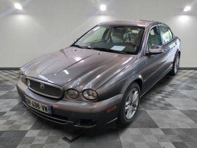 une photo d'un Jaguar argenté garé dans un garage