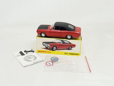 une petite voiture rouge dans une boîte avec un bâtonnet