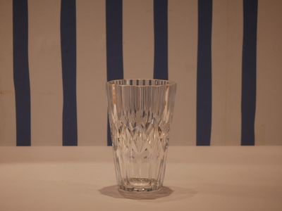 a glass that is sitting on a table in front of a striped wall