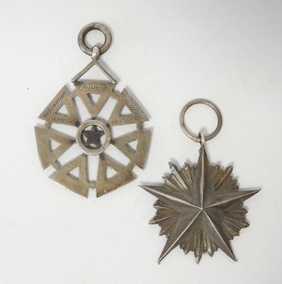deux objets métalliques argentés posés sur une surface blanche ; l'un est orné d'une étoile et l'autre d'une étoile