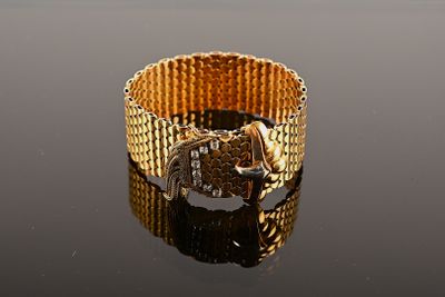 an image of a close up of a gold bracelet on a table