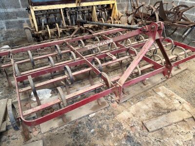 un vieux tracteur et une charrue rangés dans une grange