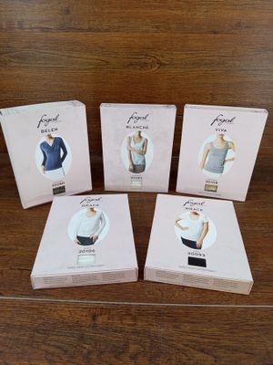 quatre cartons de vêtements pour femmes posés sur une table en bois