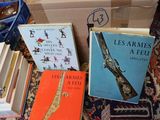 several books are sitting on a carpet next to a pile of other books